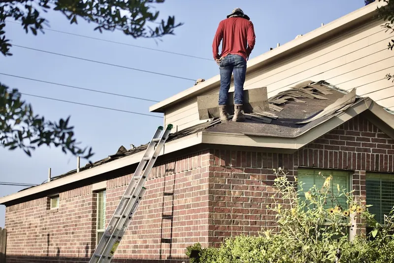 Professional roofer working on a residential roof in Granger West